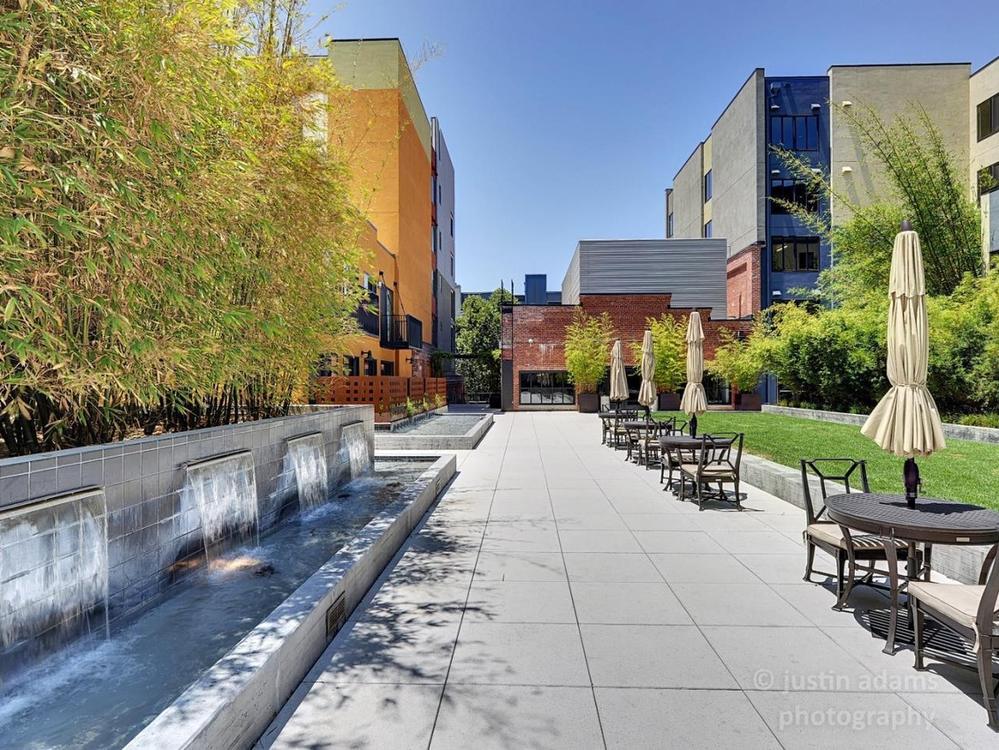 The BBQ area terrace — dining tables and umbrellas alongside the courtyard fountain